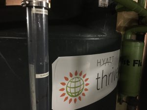 The tours of this system followed a spate of rainy days, so the system was holding more than 73,800 L (19,500 gal) of collected water. Green first flush tanks screen larger particles from the collected water. Mesh filter bags inside the tanks provide additional screening for finer materials.